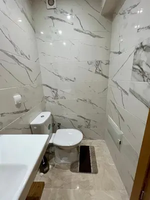 a white bathroom with a toilet and a sink at Apparemment deux chambres salon 16 in Marrakech