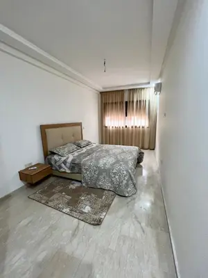 an empty bedroom with a bed and a window at Apparemment deux chambres salon 16 in Marrakech