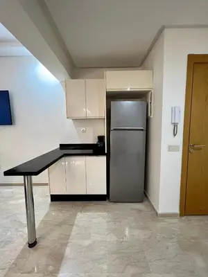 a kitchen with a black table and a refrigerator at Apparemment deux chambres salon 16 in Marrakech