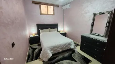 a small bedroom with a bed and a mirror at Appartement 7 min de l'aéroport de Marrakech in Marrakech