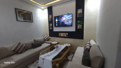 a living room with a couch and a flat screen tv at Appartement 7 min de l'aéroport de Marrakech in Marrakech