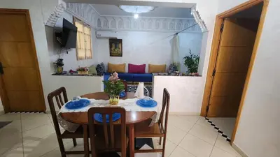 a dining room with a table and chairs and a couch at Appartement 7 min de l'aéroport de Marrakech in Marrakech