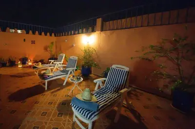 a patio with three chairs and a table at La lune de Marrakech Riad in Marrakech