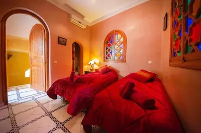 two beds in a room with red sheets at La lune de Marrakech Riad in Marrakech