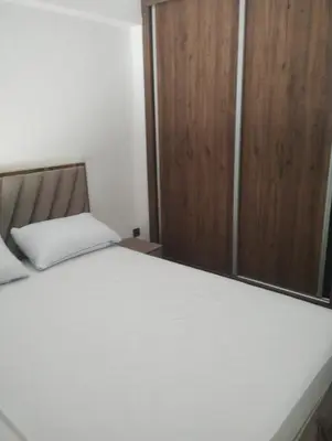 a bedroom with a bed and a wooden cabinet at Nour 5 marrakech in Marrakech