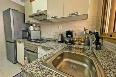 a kitchen with a sink and a refrigerator at Magnifique appartement spacieux avec une belle terrasse ensoleillée in Marrakech