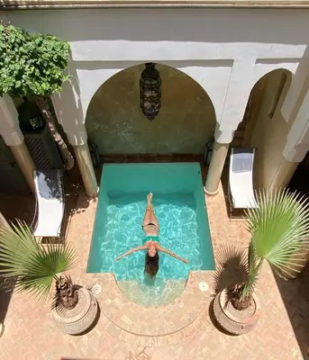 a person swimming in a pool in a house at Riad des Fragrances dar el Bacha in Marrakech