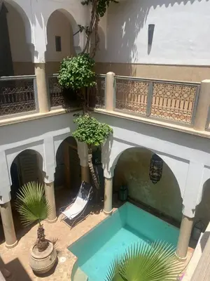 a swimming pool in the courtyard of a building at Riad des Fragrances dar el Bacha in Marrakech