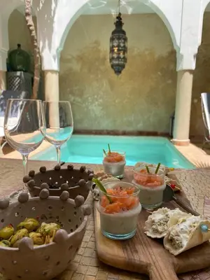 a table with bowls of food and glasses of wine at Riad des Fragrances dar el Bacha in Marrakech