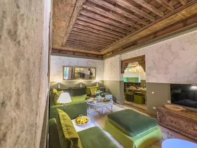 a living room with green chairs and a table at Maison Maria Palmeraie in Marrakech