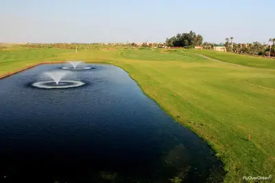 an aerial view of a golf course with a body of water at Maison Maria Palmeraie in Marrakech