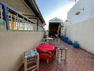 a patio with tables and chairs on a building at Riad Mama Toutou in Marrakech