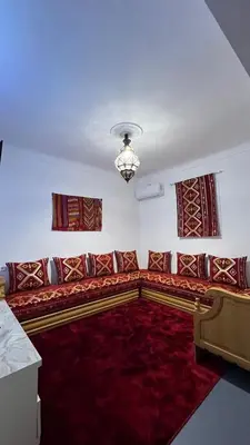 a living room with a couch and a red rug at Riad dar Benaarab 2 aéroport 800 M in Marrakech