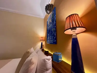 a bedroom with a bed with a lamp next to it at Riad Taghia in Marrakech