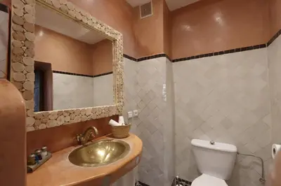 a bathroom with a sink and a toilet and a mirror at Riad 22 - L'Etoile d'Orient in Marrakech