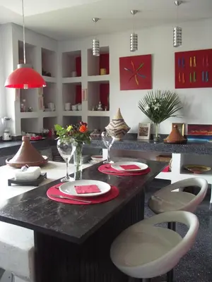 a kitchen with a table with plates and wine glasses at Villa Loanaelle in Marrakech