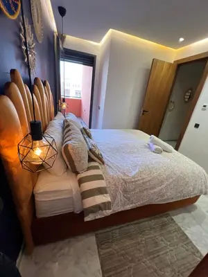 a bedroom with a large bed with a wooden headboard at Luxury apartment in center Of Marrakech City in Marrakech