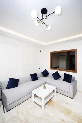 a white living room with a couch and a table at Appartement Marrakech Hivernage. in Marrakech