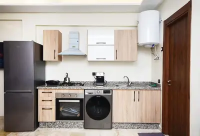 a kitchen with a refrigerator and a dishwasher at Appartement Marrakech Hivernage. in Marrakech