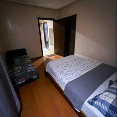 a bedroom with a bed and a chair in it at Gueliz budget Stay in Marrakech