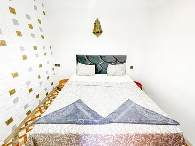 a bedroom with a bed with a quilt on it at Sun Hostel in Marrakech