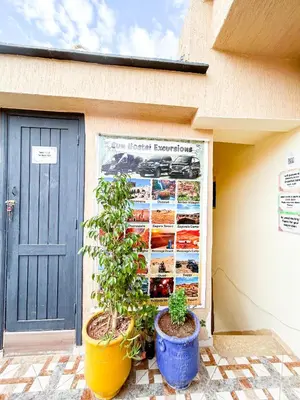 a building with two potted plants in front of a garage at Sun Hostel in Marrakech