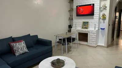 a living room with a blue couch and a table at OASIS PALM MARRAKECH APARTMENT- 5 Piscines in Marrakech