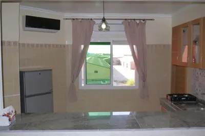 a kitchen with a window and a refrigerator at studio, à proximité de la gare in Marrakech