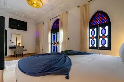 a bedroom with a bed and stained glass windows at The Grand Riad and Spa in Marrakech