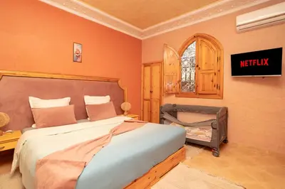 a bedroom with a bed and a tv on the wall at Villa Korima in Marrakech