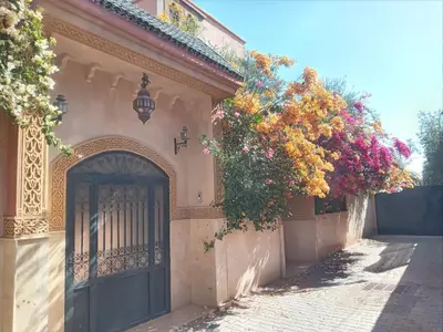 an entrance to a building with a gate and flowers at Villa Korima in Marrakech