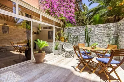 a patio with a wooden table and chairs at Luxury Duplex - Private Jacuzzi - Center Hivernage in Marrakech