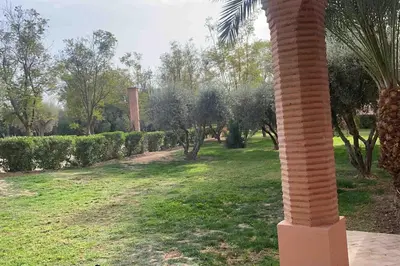 a column in a park with trees and bushes at NEW appartement in palmeraie in Marrakech