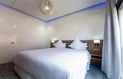 a bedroom with a large white bed with a blue stripe at Villa HAW Marrakech in Marrakech