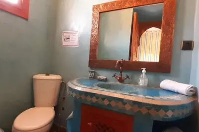 a bathroom with a sink and a toilet and a mirror at Villa Amerchiche in Marrakech