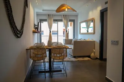 a living room with a table and chairs and a couch at L'appart by Louhou Collection in Marrakech