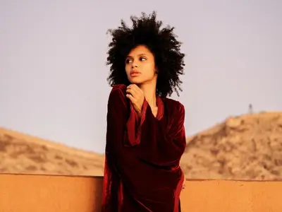a woman is standing next to a wall at Al Badiya Marrakech in Marrakech