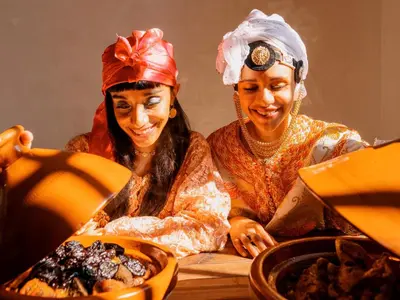 two women sitting at a table looking at food at Al Badiya Marrakech in Marrakech