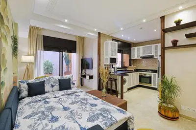 a living room with a bed and a kitchen at Oasis - Appartement Authentique à Gueliz in Marrakech