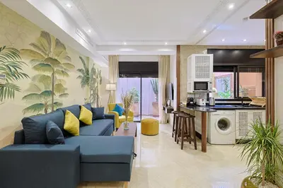 a living room with a blue couch and a kitchen at Oasis - Appartement Authentique à Gueliz in Marrakech