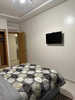 a bedroom with a bed and a flat screen tv at Cosy studio au centre de Marrakech Netflix in Marrakech