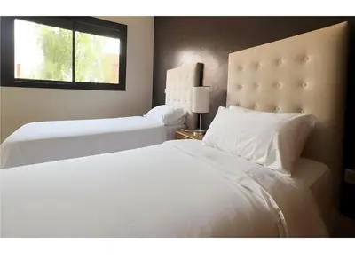 a bedroom with two white beds and a window at Bright condo w/ pool in Marrakech