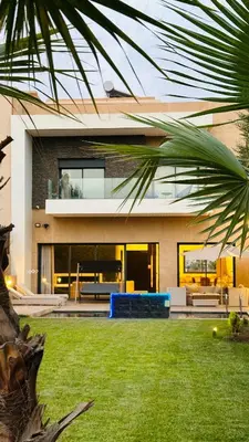 a house with a palm tree in front of it at Argan Golf Villa 4-bed Marrakech in Marrakech