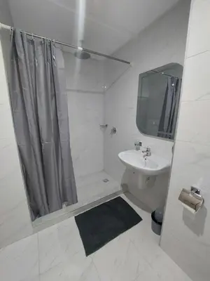 a white bathroom with a shower and a sink at Centre Marrakech, Chic et Calme in Marrakech