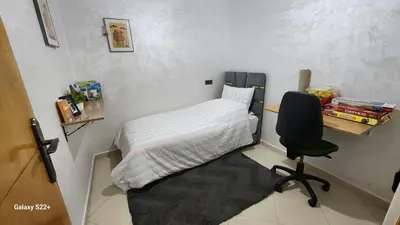 a small room with a bed and a desk and a chair at Appartement B à 7min de l’aéroport de Marrakech in Marrakech