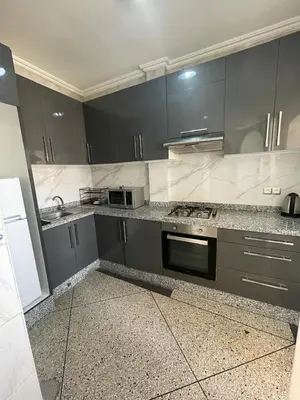 a kitchen with gray cabinets and a stove top oven at Luxury Apartment in Marrakesh in Marrakech