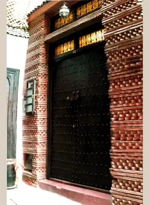 a black door on a brick building at Riad Signature in Marrakech