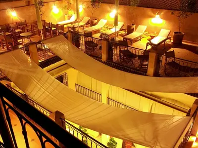 a large room with tables and chairs and a hammock at Riad Signature in Marrakech