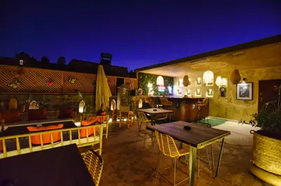 a rooftop patio with tables and chairs at night at Riad La Petite Majorelle in Marrakech