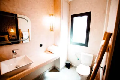 a bathroom with a sink and a toilet and a window at Riad La Petite Majorelle in Marrakech